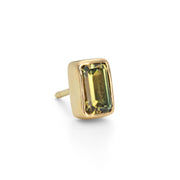 A single gold stud earring with a green square-shaped sapphire centrepiece.