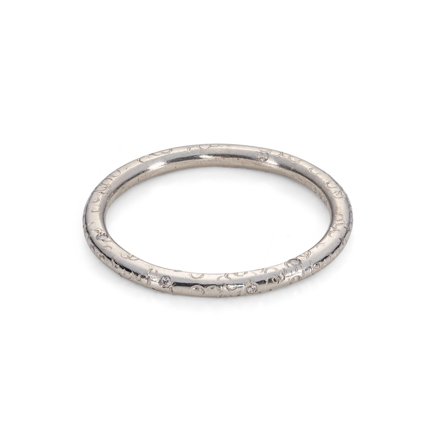A 'Dartmoor' wedding band platinum ring with round SI flush set brilliant cut diamonds on a band. circle texture on a round band, scattered diamonds. on a white background